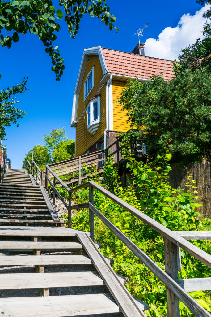 Puiset Pispalan portaat nousevat jyrkästi ylös Pispalanharjua, vanhojen puutalojen reunustamana Tampereella.